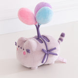 Quarter side view of the Pusheen 15th Anniversary Balloons Plush toy. Pusheen the cat is tied to three multi-colored balloons. Her normally brown details are dark purple.