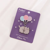 Pusheen 15th Anniversary Deluxe Pin affixed to its purple backer card with silver foil details.