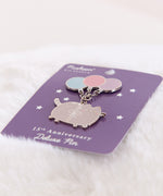15th Anniversary Deluxe Pin shown at an angle to showcase the reflective outline of the dangling pin.