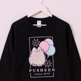 Black Pusheen Sweatshirt hangs on a hanger. The fair-themed crew neck sweatshirt is apart of the Pusheen's 15th Anniversary collection.