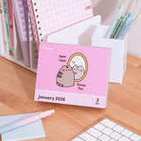 Calendar for January 2, 2026 with a graphic of Pusheen the Cat looking in a mirror with the phrase "New Year, Same You" a pink background.