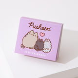 Front view of the front cover of the Pusheen 2026 day-to-day calendar. The purple cover shows a graphic of three gray cats. 