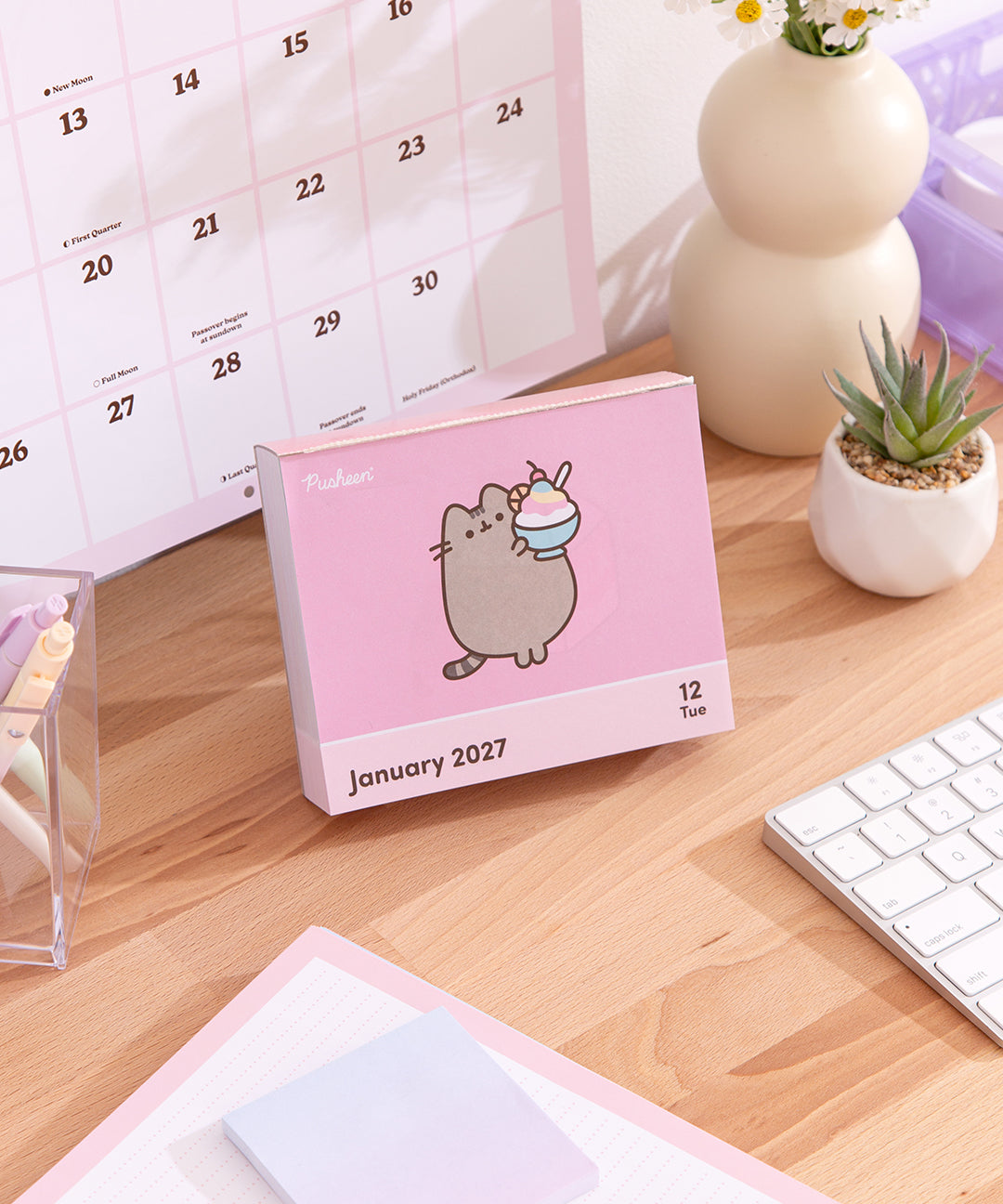 Pusheen 2027 Daily Desk Calendar page for day of January 12, 2027. The graphic on this page shows Pusheen standing and holding a tropical shaved ice treat. 