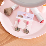 Balloon earrings on backing card. The silver outlined earrings show a pair of Pusheen's tied to a balloon. 