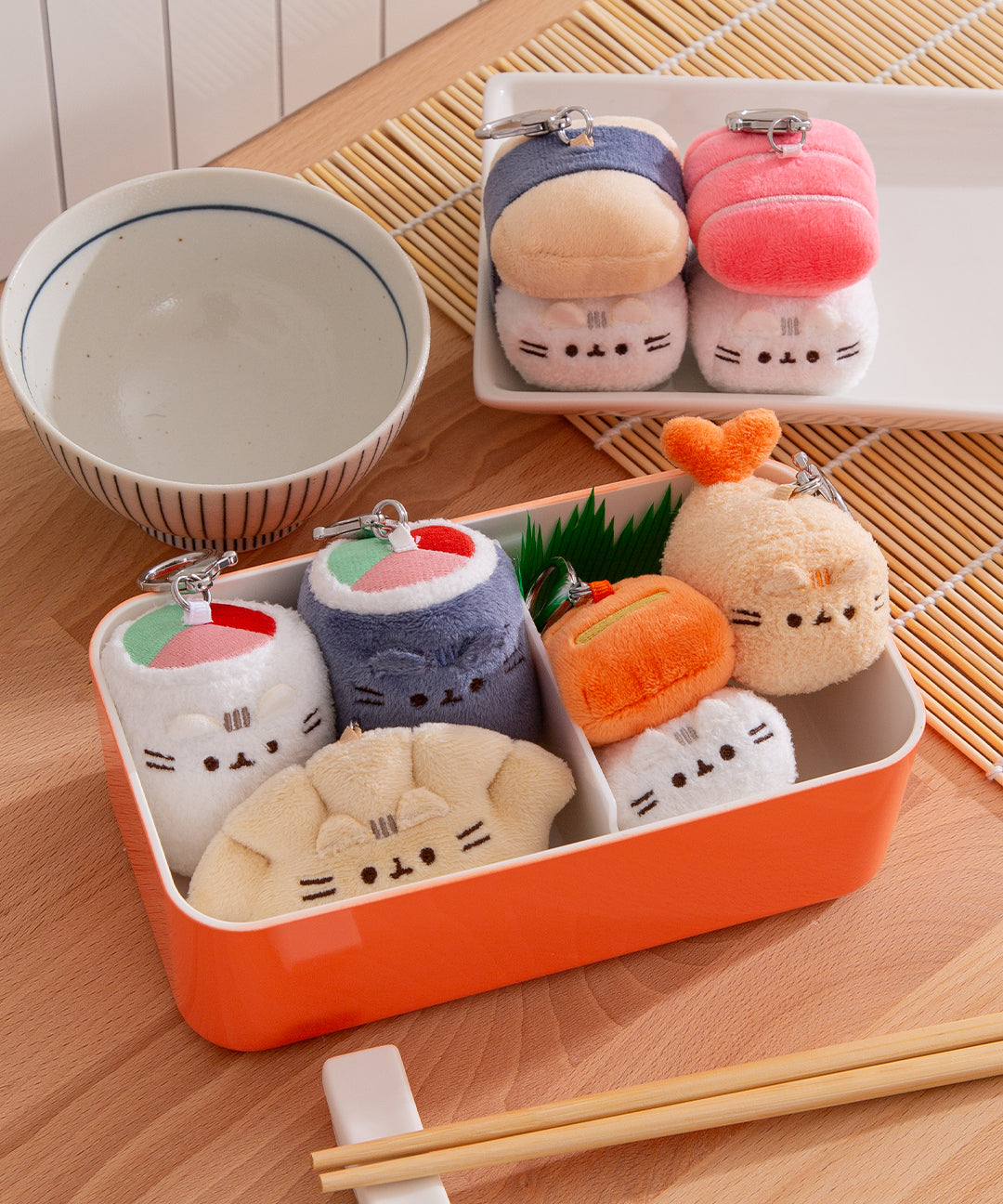 Bento Box Surprise Plush sit in bento contains and plates to demonstrate their small size.