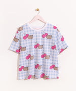 Hung on a pink hanger, the Pusheen Pajama Tee is hung to show the full length of the oversized t-shirt. The blue and white checkered tee has printed all over graphic of Pusheen and cherries. 
