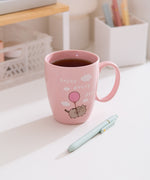 Enjoy Every Day Mug sits on a white desktop with tea inside the pink mug.