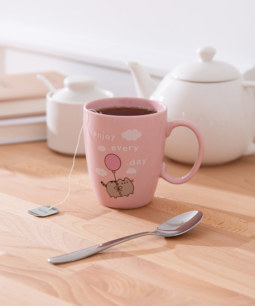 Enjoy Every Day Mug sits on a white desktop with tea inside the pink mug.