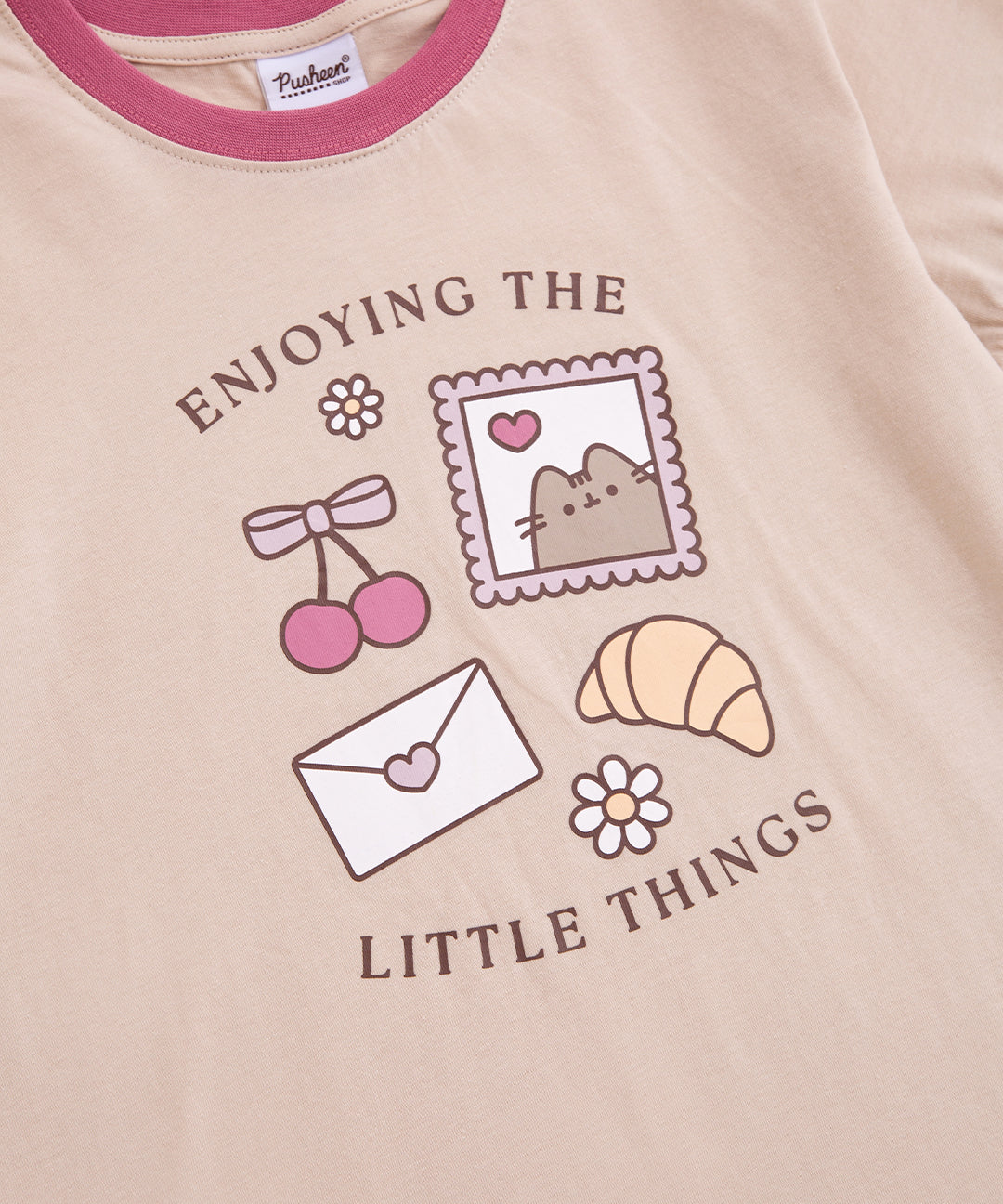 Close-up of graphic on the Pusheen pj set where the gray tabby cat reminds you to enjoy the little things like a sweet cherry or letter from a friend.