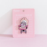 Front view of the Pusheen Gamer Chair Deluxe Pin on its pink backer card. A grey cat sits in an oversized chair to play online games.