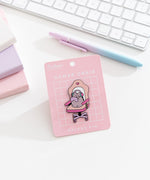 Pusheen Gamer Chair Deluxe Pin on a pink backer card. The large pin features Pusheen the Cat sitting in an oversized gaming chair with wearing a headset and holding a purple gaming controller.