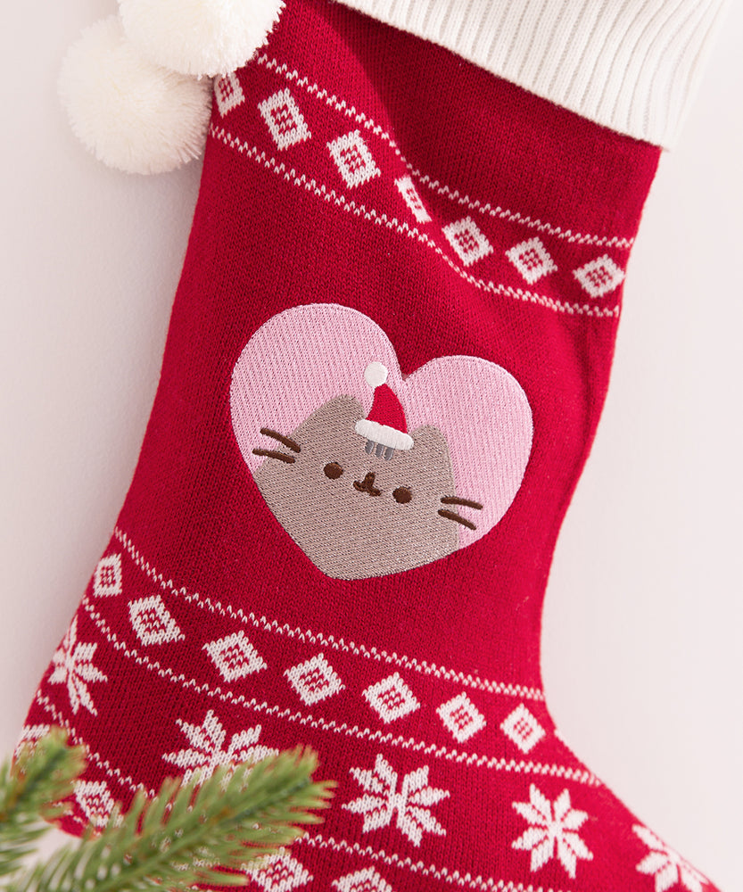 Close-up of the white and red knit details on the stocking. The foot of the stocking includes three lines of white knit snowflake patterns.