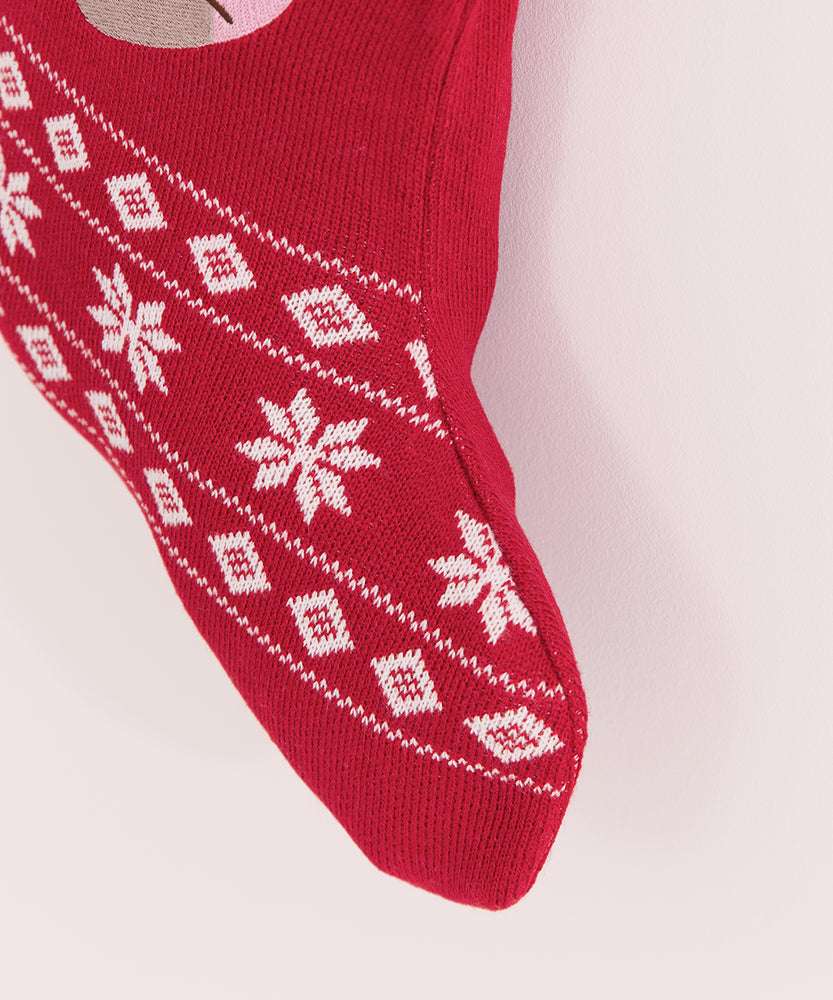 Close-up of the white and red knit details on the stocking. The foot of the stocking includes three lines of white knit snowflake patterns.