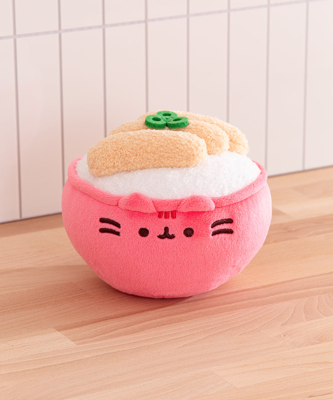 Front view of the Pusheen Katsu Rice Bowl Plush where Pusheen the Cat takes the form of a rice bowl topped with tempura and scallions.