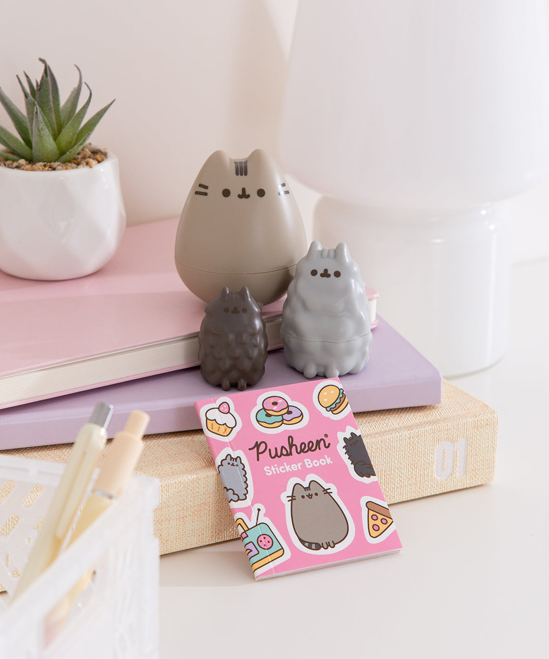 In front of the three cat nesting dolls is the included sticker book that comes in the Pusheen Nesting Dolls set.