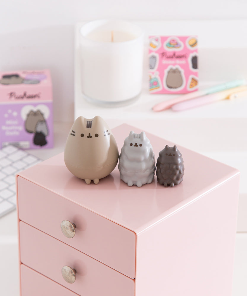 Pusheen Mini Nesting Dolls set includes three cat-shaped nesting dolls featuring Pusheen, Stormy, and Pip. Stormy and Pip's dolls have a textured surface to mimic their fur textures.