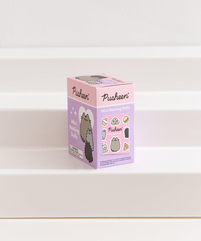 Side view of the Pusheen Mini Nesting Dolls packaging showing a preview of the included sticker book in the box.