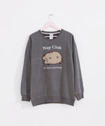 Gray sweatshirt with a sleeping cat hangs on a light pink hanger.