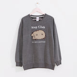 Gray sweatshirt with a sleeping cat hangs on a light pink hanger.