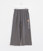 Gray sweatpants hanging on a white bottoms hanger to show full silhouette of wide-leg pant.