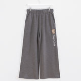 Gray sweatpants hanging on a white bottoms hanger to show full silhouette of wide-leg pant.