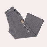 Gray sweatpants with "Nap Club" embroidery text going down one leg of the pants below the side pocket.