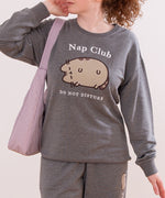 Close-up of front graphic on gray sweatshirt. Pusheen the Cat is shown in a flocked fabric and the phrases "Nap Club" and "Do Not Disturb" are embroidered in white.