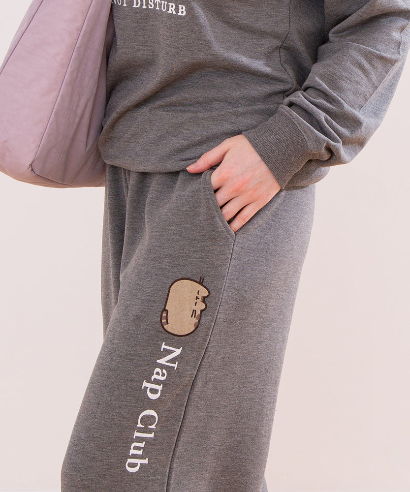 Close-up view of a model wearing the Pusheen matching loungew set. The model has their hand in the side pocket. The embroidery down the side of the pant can be see in this image.