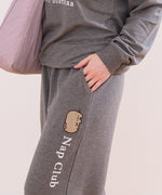 Close-up view of a model wearing the Pusheen matching loungew set. The model has their hand in the side pocket. The embroidery down the side of the pant can be see in this image.