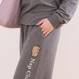 Close-up view of a model wearing the Pusheen matching loungew set. The model has their hand in the side pocket. The embroidery down the side of the pant can be see in this image.