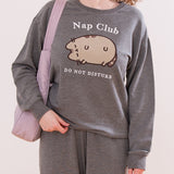 Model wearing heather gray Nap Club Sweatshirt with a large front graphic that's flocked and embroidered.