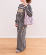 Pusheen Nap Club Loungewear Sweater lies on a flat surface. The gray sweatshirt features Pusheen’s face on the front in a flocked material.