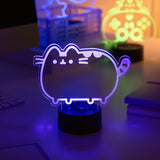 Pusheen Otaku Lamp light shaped like a cat on a desk with other neon lights in the background.