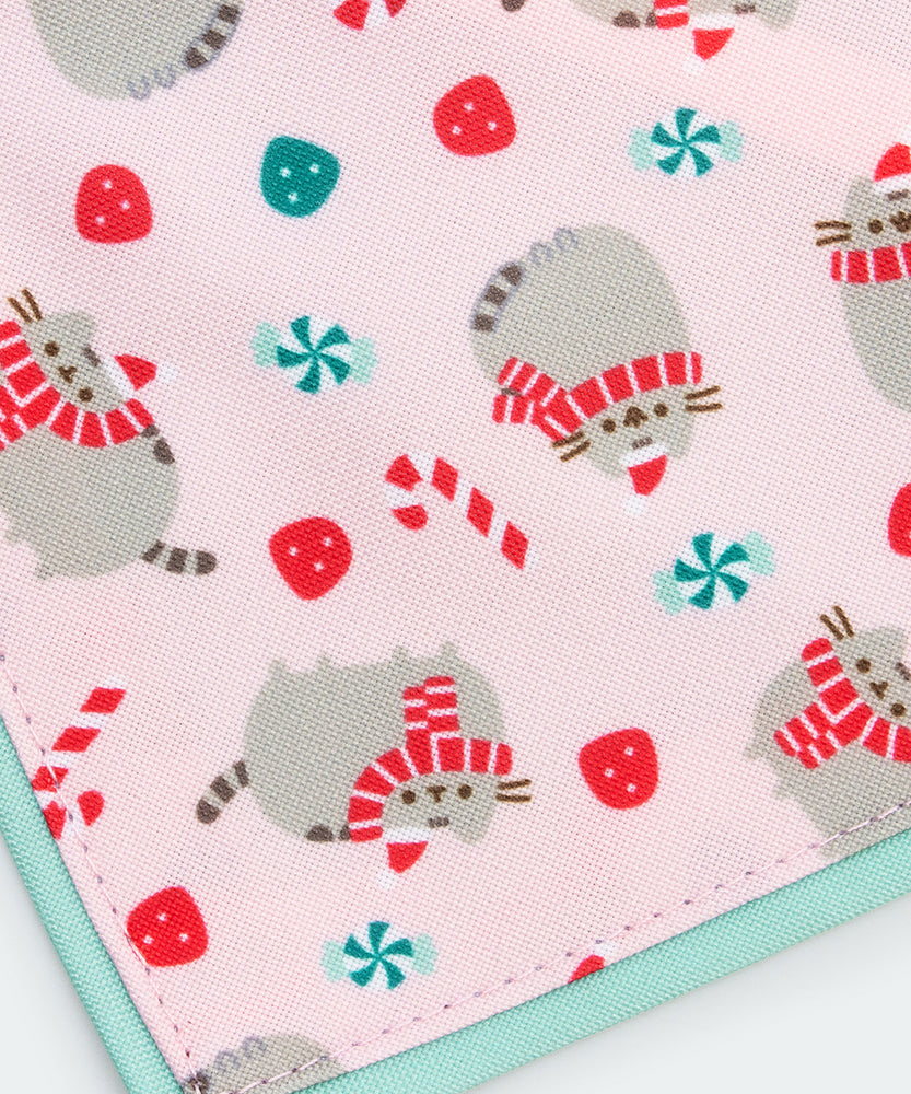 Pusheen Pet Holiday collar and bandana set in packaging that states that the set are seasonal collars. The Pusheen eating a candy cane charm and bandana pattern are displayed at the front. 