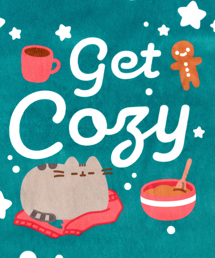 Close-up of the large center graphic on the Holiday Pet Blanket. The graphic has the text 'Get Cozy' surrounded by a gray tabby cat, mug, gingerbread man, and baking bowl.