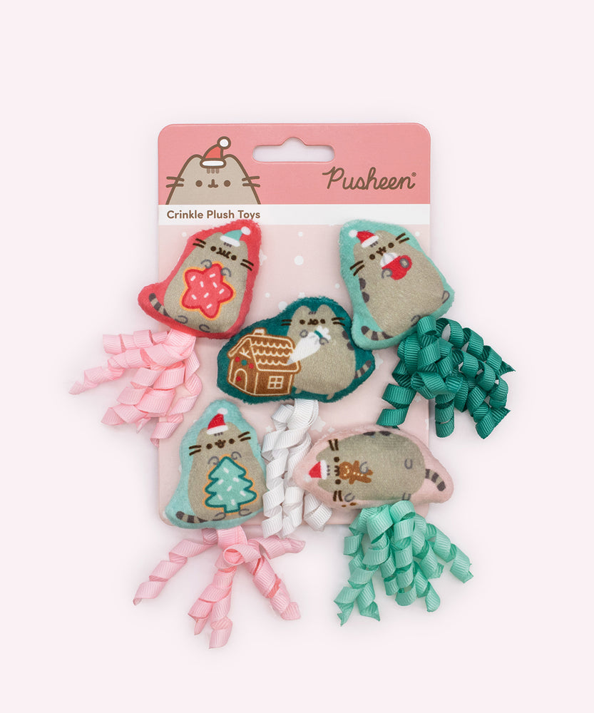 Holiday baking-themed pet plush toys on their packaging backer card. The card is red and white and has the text "Pusheen" and "crinkle plush toys."