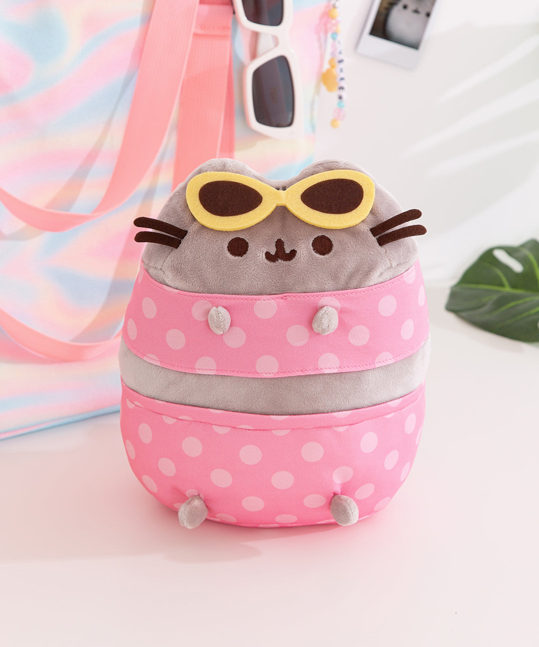 Pusheen Pool Party Plush features Pusheen wearing a polka dot two-piece bikini and yellow sunglasses.