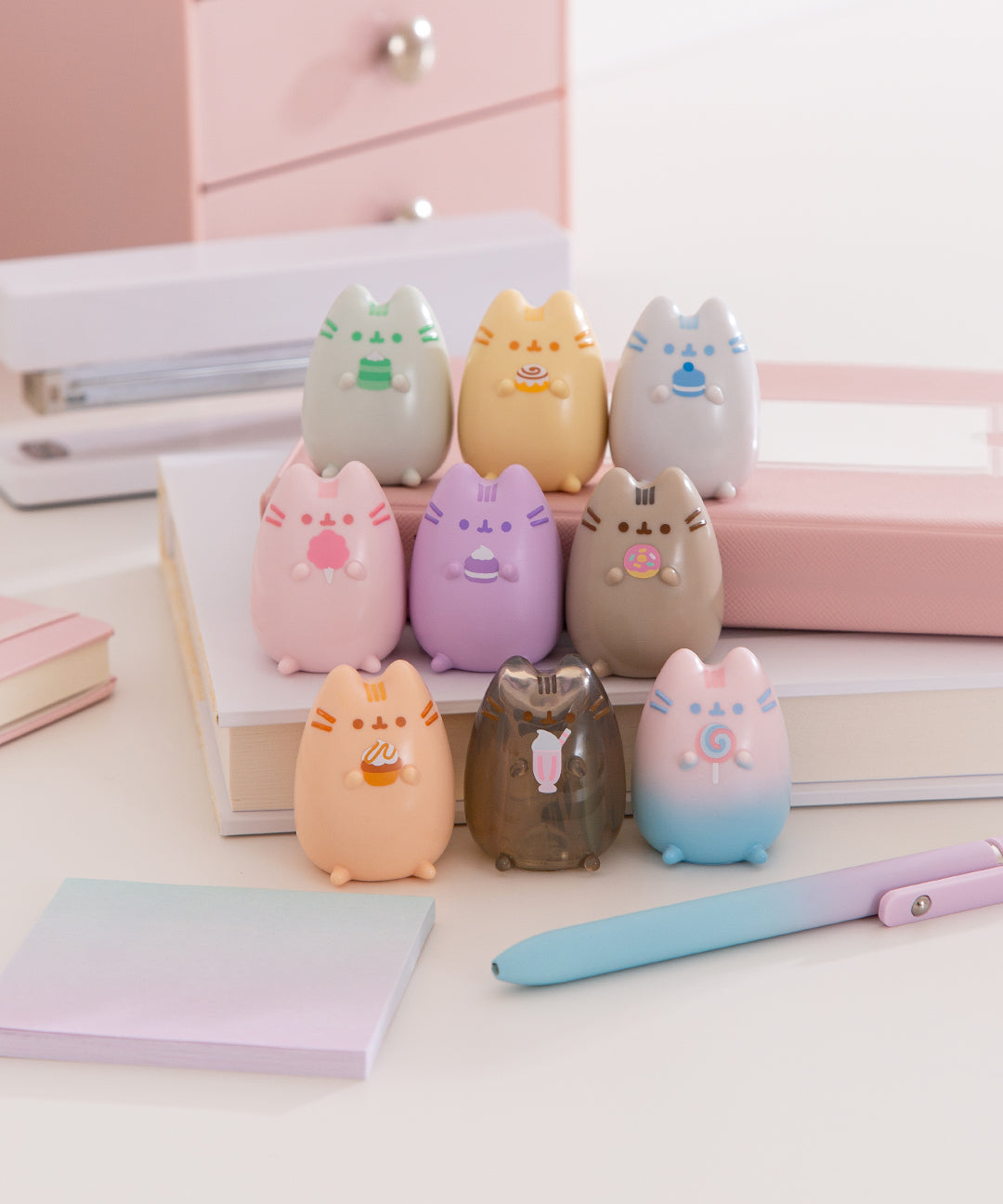 Set of 9 Pusheen Surprise Mini Figurines where Pusheen the Cat is shown in a variety of colors holding different sweet treats.