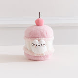 Front view of the Pusheen Sweets Cherry Macaron Plush. The removable white Pusheen plush sits within a macaron environment with a light pink cherry at the very top.  