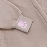 Close-up of a embroidered pink paw print on the expanded ribbed cuff of the brown onesie.