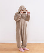 Model wearing a beige cat-themed onesie and showing off the cat face details on the hood.