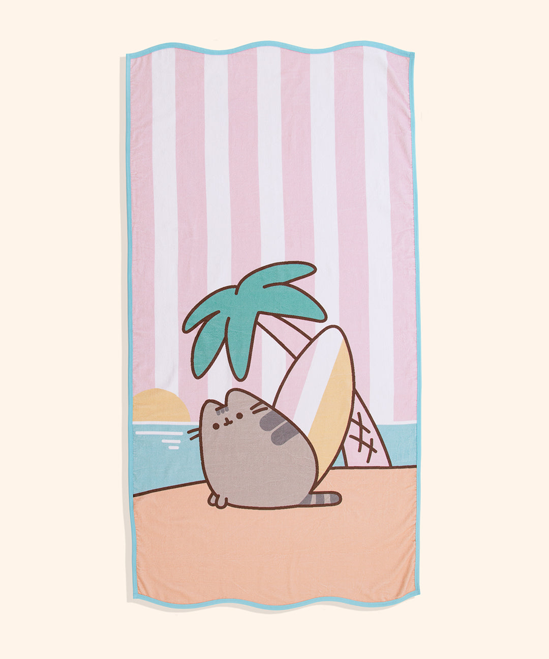 Full view of the Pusheen Tropical Vacation Beach Towel. The cotton towel has a printed graphic of Pusheen on a beach with a surf board palm tree with a sunset scene in the background. The top and bottom of the towel have a wavy edge.
