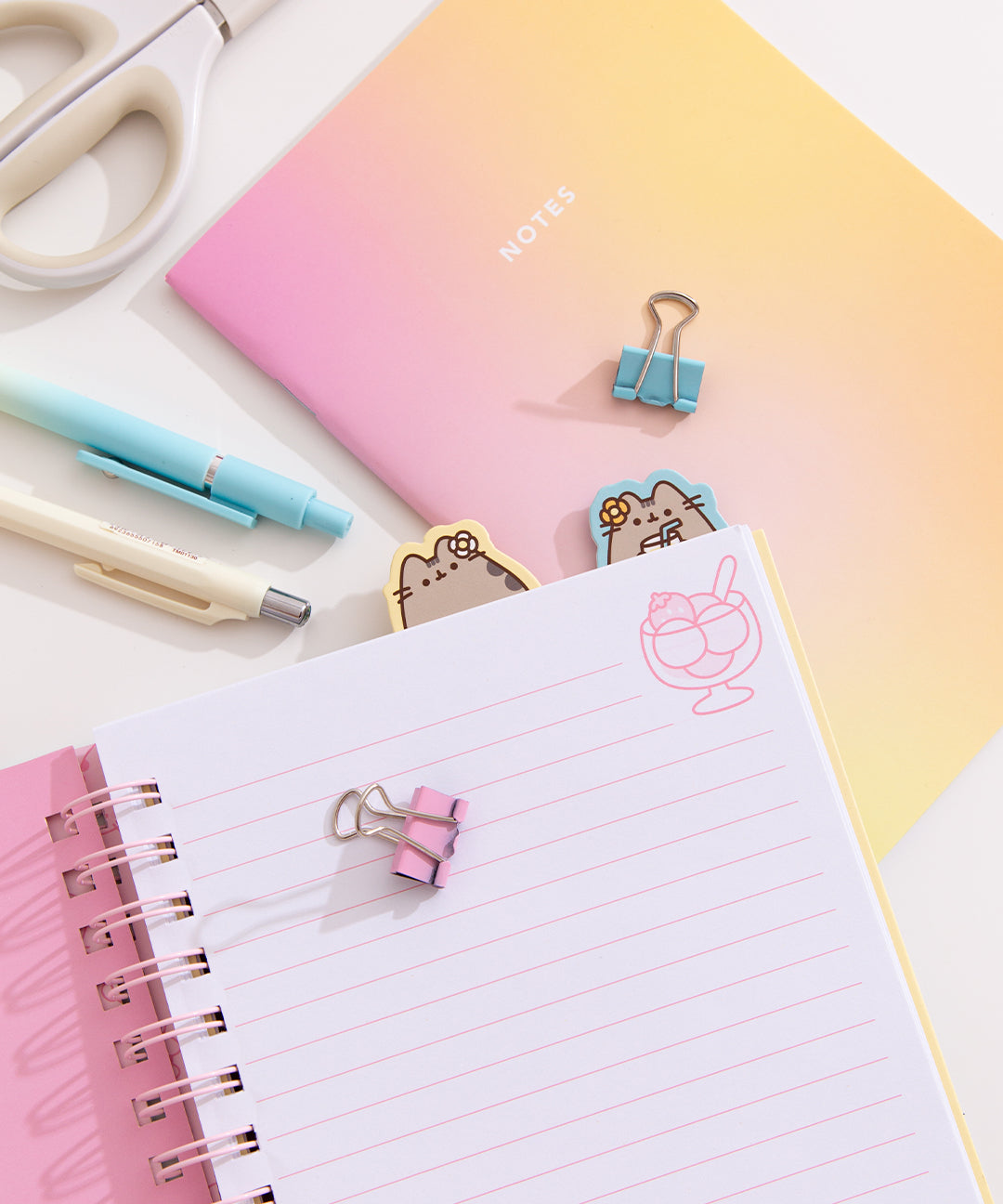 Notebook opened to a page with writing lines and a graphic of a scooped icey dessert.