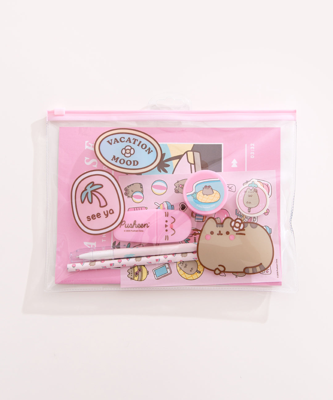 Front view of the enclosed Pusheen Tropical Vacation Stationery Set. The items in the set are encased in a clear and pink plastic resealable pouch with a graphic of Pusheen the Cat and two tropical sticker graphics that say "vacation mood" and "see ya"