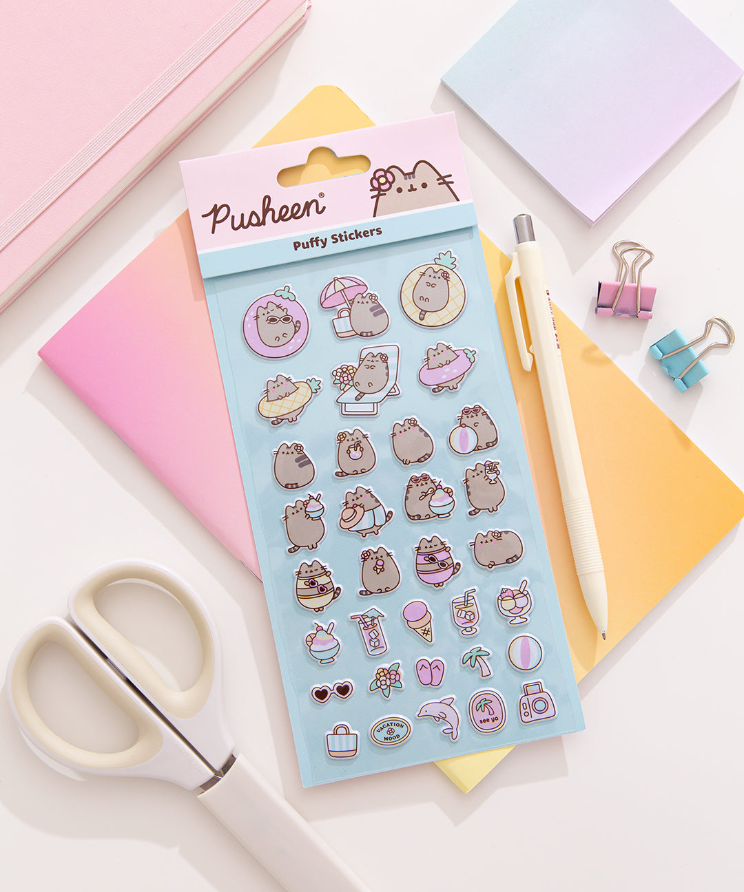 Pusheen Tropical Vacation Sticket Sheet in its packaging on a desk surrounded by stationery items.