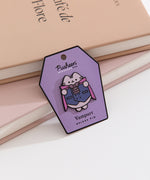 Vampire Pusheen pin shows the tabby cat is a purple hue wearing a purple cape, waistcoat, and bat bowtie. 