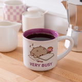 Pusheen Very Busy Mug is white with a purple interior and features Pusheen the Cat sleeping on papers.