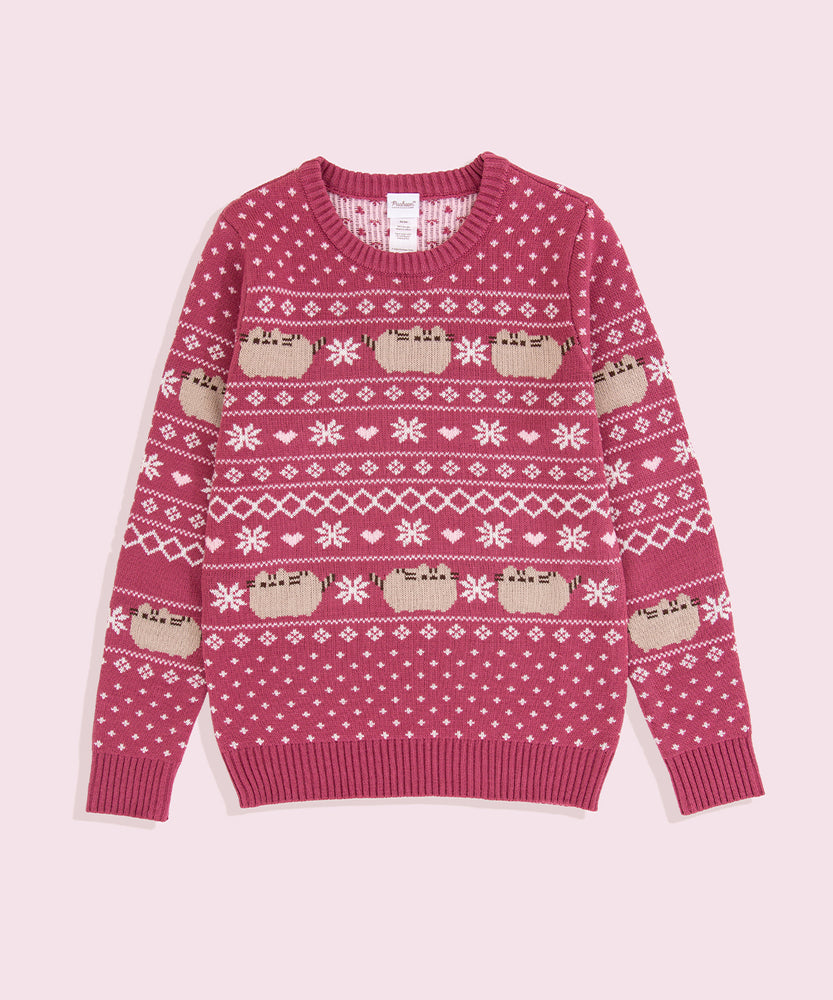 Red knit sweater lies on a light background. The sweater has knit graphics of Pusheen the Cat, snowflakes, and hearts.