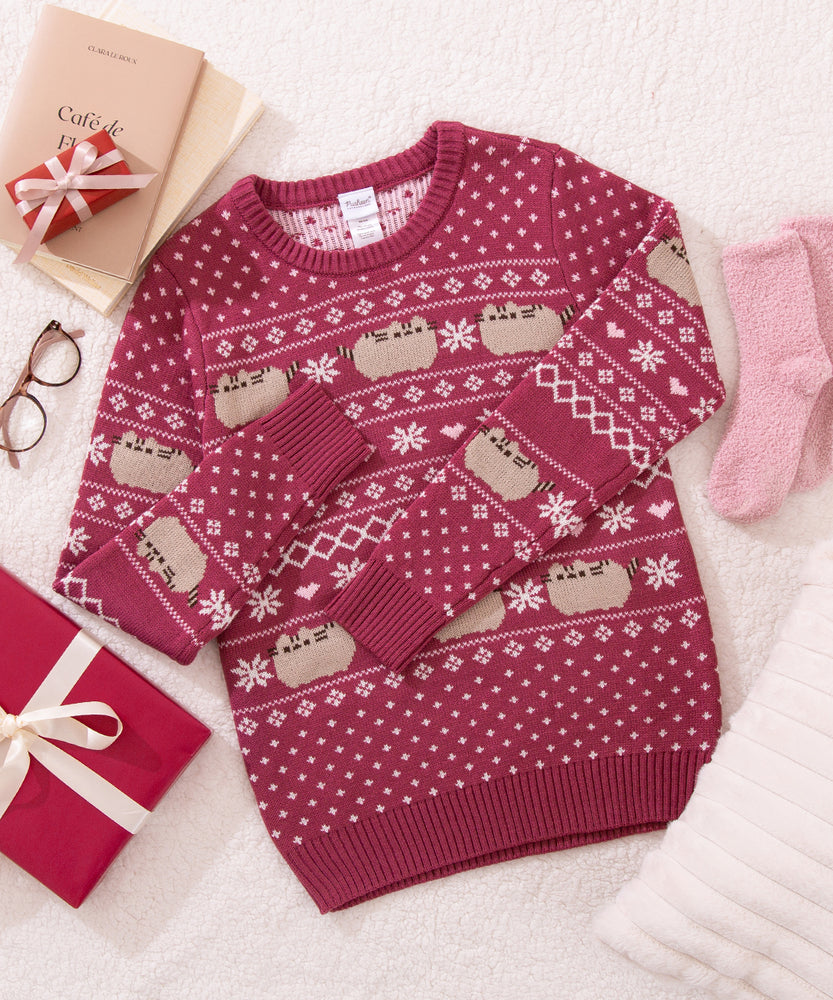 Winter Knit sweater with festive pattern on a white surface with gift boxes and glasses.