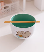 The included chopsticks of the Pusheen Yum Ramen Bowl sit in the notch on the top of the white ceramic bowl. 